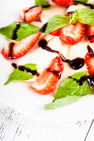 Caprese salad with strawberry, mozzarells, basil and balsamicの写真素材