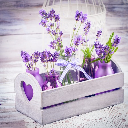 Lavender in bottles, decor provance style, wooden box and birdcage on crochet tableclothの写真素材
