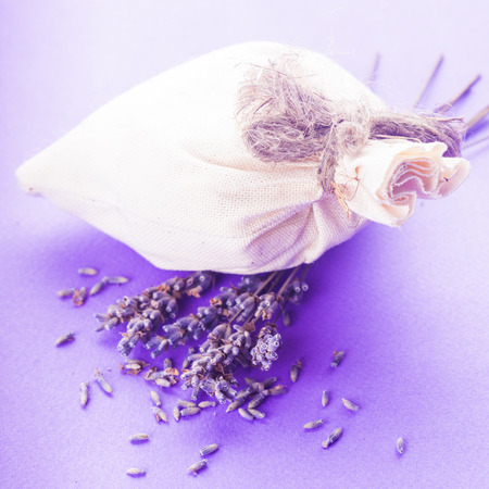 Dried lavender sachet over purple bacgkround with flowersの写真素材