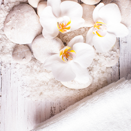 Sea salt, rebbles with orchids and white towels, spa conceptの写真素材