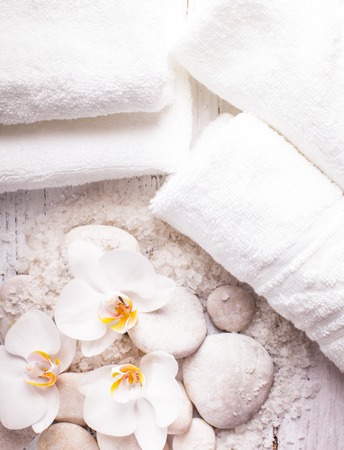 Sea salt, rebbles with orchids and white towels, spa conceptの写真素材