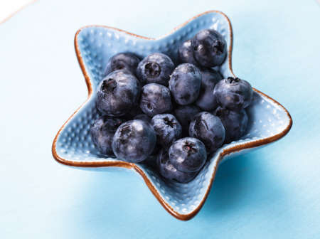 Blueberries close up in a blue bowlの写真素材