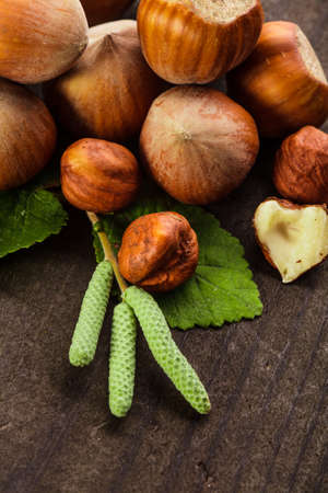 Hazelnuts with shell and green leaf on the wooden tableの写真素材