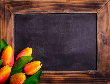 Tulips with chalkboard on a wooden - spring greetingsの写真素材