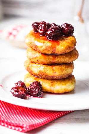 cheese pancakes with cherry jam on the plateの写真素材
