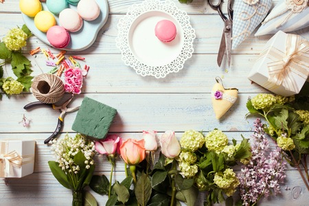 Box with flowers and macaroons on wooden tableの写真素材