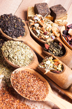 Various of dried tea in wooden scoops and spoonsの写真素材