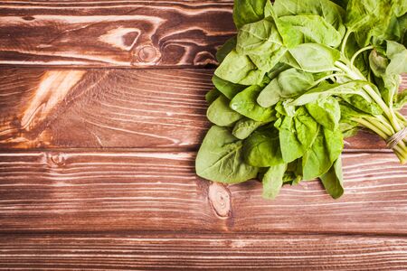 Spinach bunch on the wooden table with copy spaceの写真素材