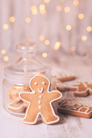 Gingerbread cookies on a table and Christmas lights on backgroundの写真素材