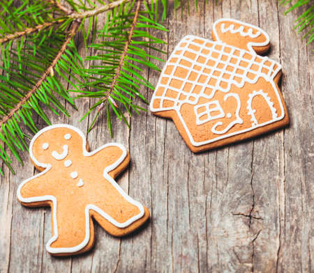 Gingerbreads and fir tree branches on the wooden table. Christmas decor