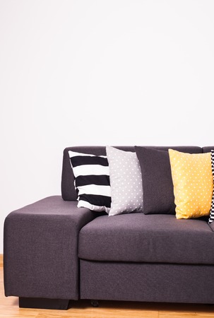 Gray sofa with many colorful pillows on it