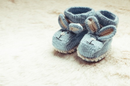 Knitted blue baby booties with rabbit muzzle for little boyの写真素材