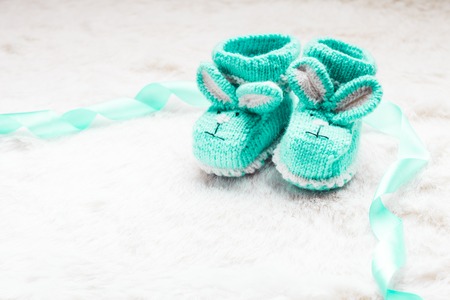 Knitted green baby booties with rabbit muzzle for little boyの写真素材