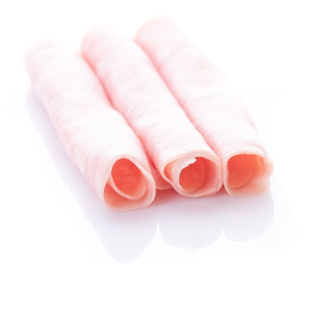 Fresh rolled ham slices isolated on whiteの写真素材