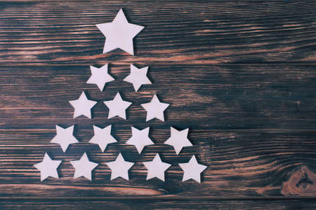 White stars in a shape of christmas tree on a wooden backgroundの写真素材