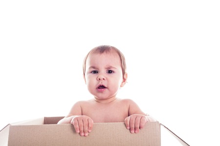 A small child crawls out of the box isolatedの写真素材