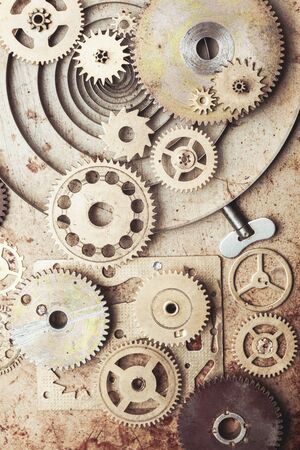 Steampunk background from mechanical clocks details over old metal background. Inside the clock,...
