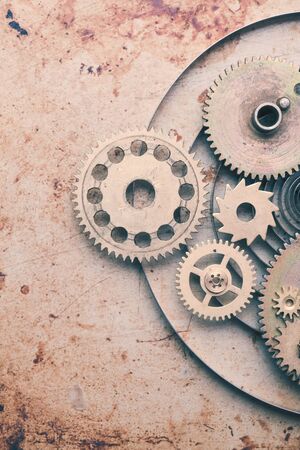Steampunk background from mechanical clocks details over old metal background. Inside the clock,...