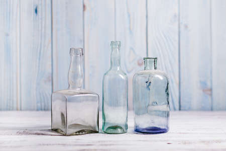 Collection of empty vintage glass bottle on a wooden background.の写真素材