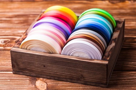 Various colors ribbon bobbins in vintage wooden boxの写真素材