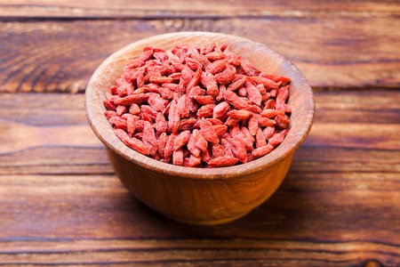 Red dried goji berries in a wooden bowlの写真素材