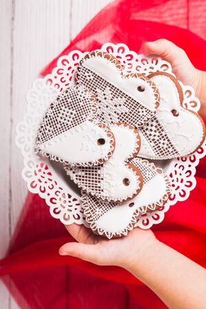 Gingerbread cookies in shape of heart in girl's handsの写真素材
