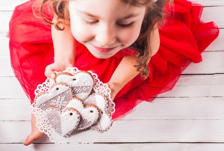 Gingerbread cookies in shape of heart in girl's handsの写真素材