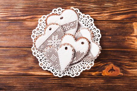 Gingerbread cookies in shape of heart with icing on a wooden backgroundの写真素材