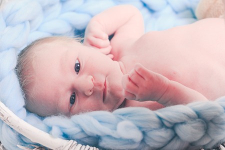 Newborn baby on blue giant crochet blanket look upの写真素材