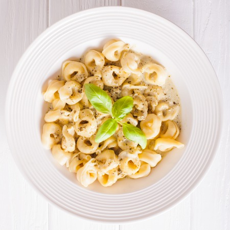 Delicious dish of tortellini with pesto in white plate. Top viewの写真素材