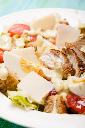 Salad Caesar in a white plate on the tableの写真素材