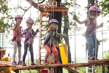 Kids on obstacle course in adventure park in mountain helmet and safety equipmentの写真素材