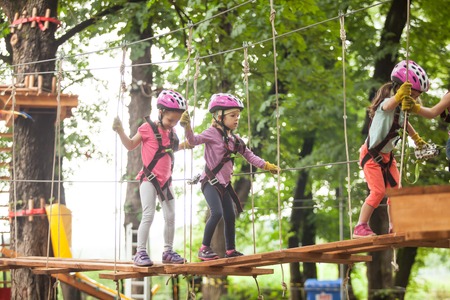 Kids on obstacle course in adventure park in mountain helmet and safety equipmentの写真素材