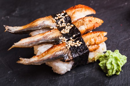Close-up of Unagi sushi with eel and wasabi on a black slate backgroundの写真素材