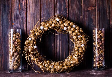 Golden acorns and pine cones in glass and wreath, decor for Christmasの写真素材