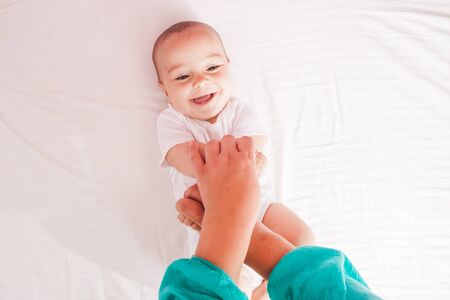 Female massaging infant hands, cute kid laughingの写真素材