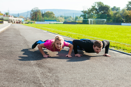 Man and woman doing push-upの写真素材