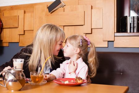 Mom and daughter enjoying life in the cafeの写真素材