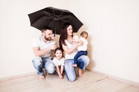 Family sitting under umbrellaの写真素材