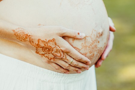 Pregnant belly closeup with mehndiの写真素材