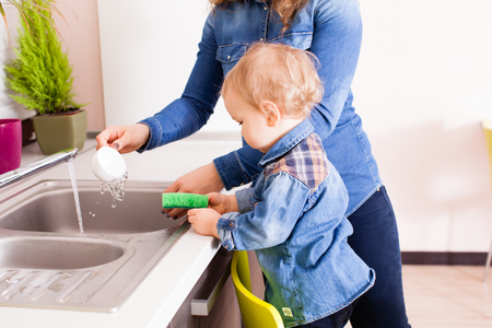 Baby boy washing dishesの写真素材