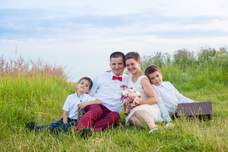 Romantic family in the field in the summer outdoorsの写真素材