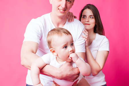 Small baby in fathers arms looking at the cameraの写真素材