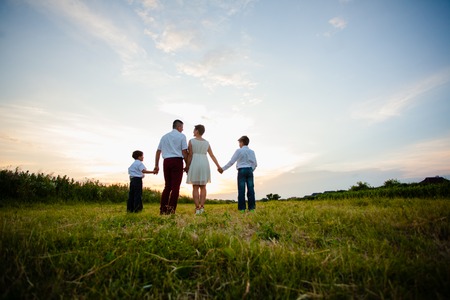 Happy family on the background of the sunsetの写真素材