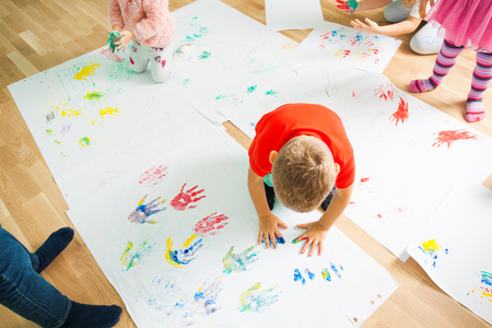 Boy making colorful imprints of his palmsの写真素材