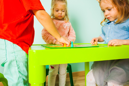 Portrait of two girls sitting at the kids tableの写真素材