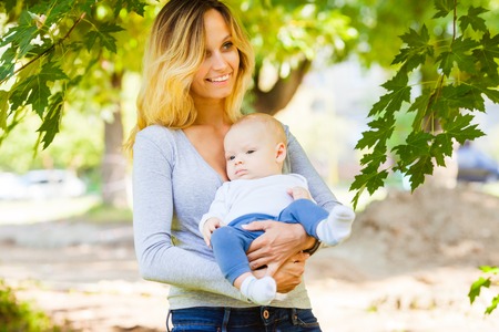 Beautiful mother with her infant boy outdoors