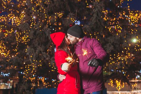 Romantic couple hugging and kissing holding bengal firesの写真素材