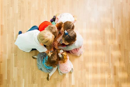 Top view of kids sitting together on a floorの写真素材