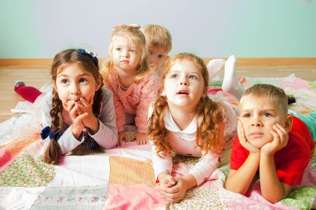 Close view of five kids laying on a floorの写真素材